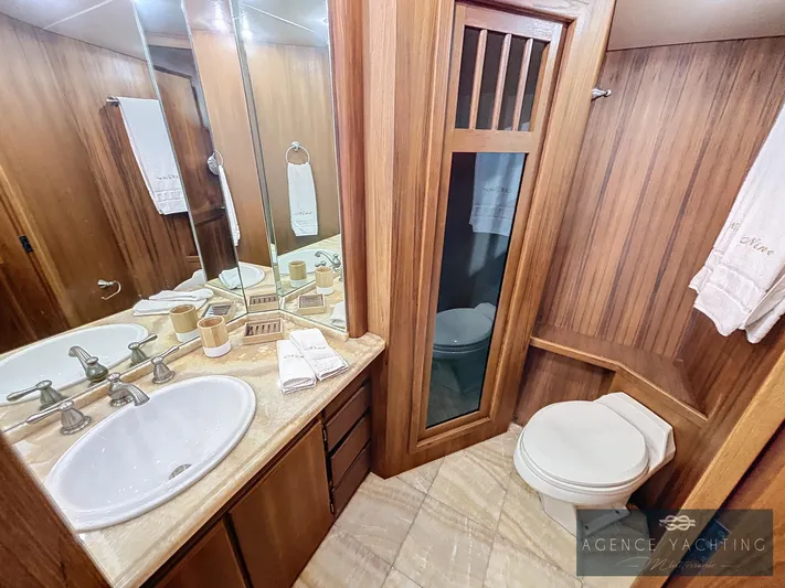  Yacht Photos Pics Luxurious bathroom in 1987 Hatteras 85 yacht with wood accents and modern fixtures.