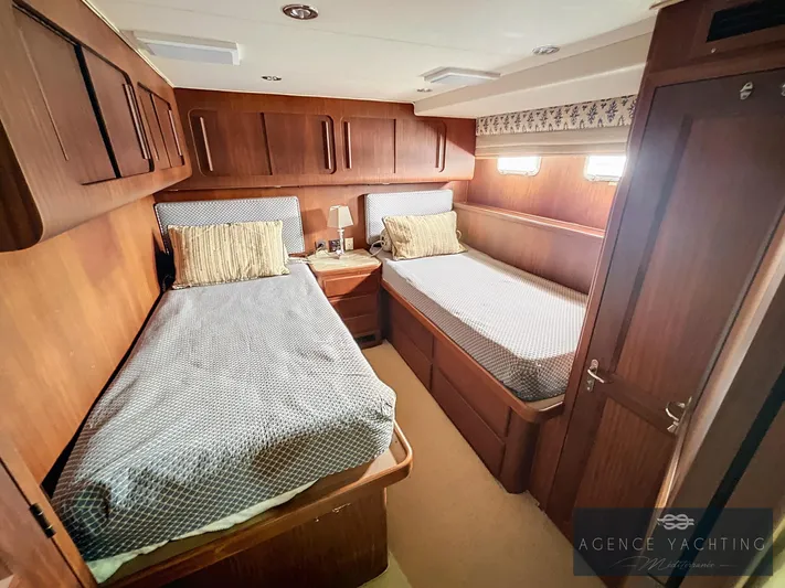  Yacht Photos Pics 1987 Hatteras 85 yacht cabin with twin beds, wooden interior, and soft lighting.