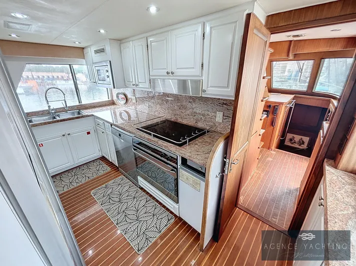  Yacht Photos Pics Luxurious 1987 Hatteras 85 yacht kitchen with modern appliances and elegant wood flooring.