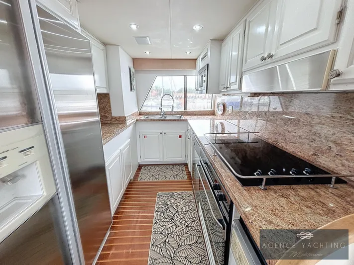  Yacht Photos Pics Luxurious kitchen interior of 1987 Hatteras 85 yacht with modern appliances and elegant design.