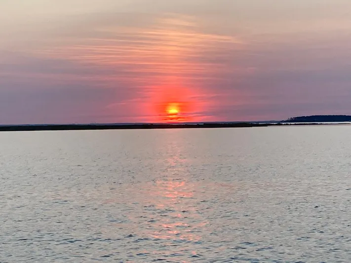 Sea-ductive Yacht Photos Pics Sunset over calm water with vibrant orange and pink hues, Catalina 375, 2011.