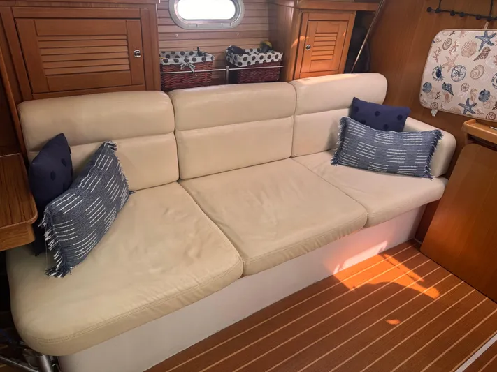 Sea-ductive Yacht Photos Pics Beige sofa with blue pillows in 2011 Catalina 375 yacht interior.