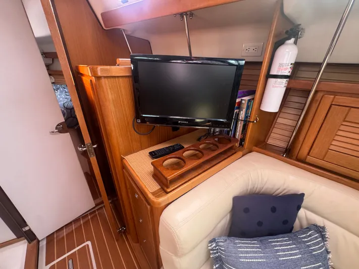 Sea-ductive Yacht Photos Pics Interior of 2011 Catalina 375 yacht with TV, fire extinguisher, and cozy seating area.