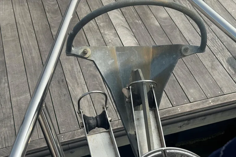 Sea-ductive Yacht Photos Pics Bow of 2011 Catalina 375 sailboat with anchor roller and wooden dock background.