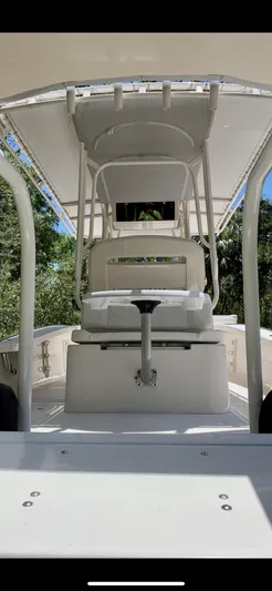  Yacht Photos Pics 2020 Calcutta 263 Center Console boat interior with seating and canopy, surrounded by greenery.