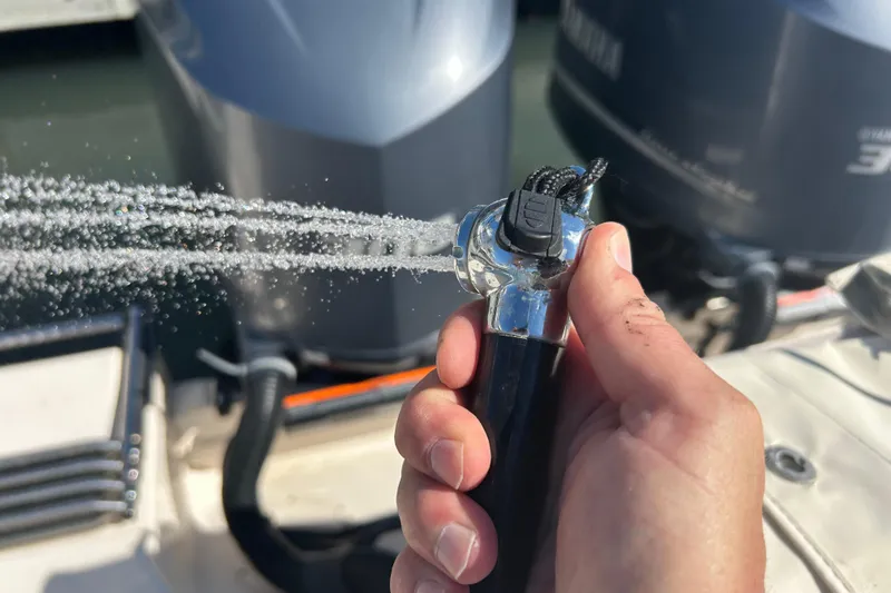  Yacht Photos Pics Hand holding a hose spraying water on a 2020 Grady-White Canyon 306 boat.