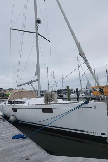 Pura Vida Yacht Photos Pics 2013 Beneteau Oceanis 48 sailboat docked at a marina on a cloudy day.