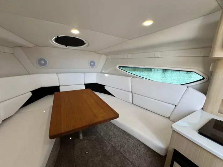 Yacht Photos Pics 2024 Regal 26 XO cabin interior with white seating and wooden table.