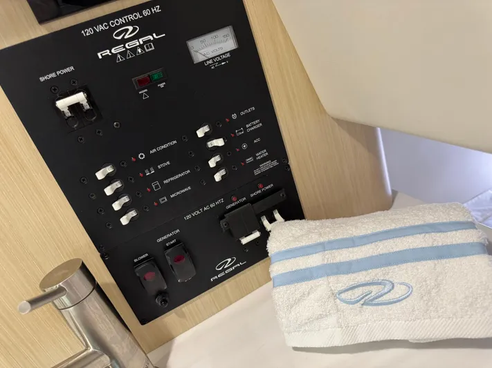  Yacht Photos Pics 2024 Regal 26 XO control panel with towel, showcasing boat's electrical system.