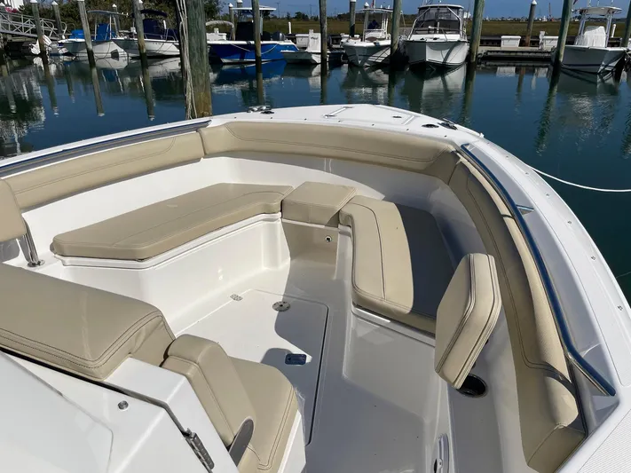 Yacht Photos Pics 2020 Pursuit S 288 boat with beige seating in a marina setting.