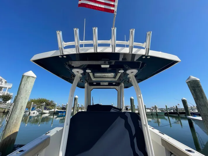  Yacht Photos Pics 2020 Pursuit S 288 boat docked, featuring a T-top and American flag against a clear blue sky.