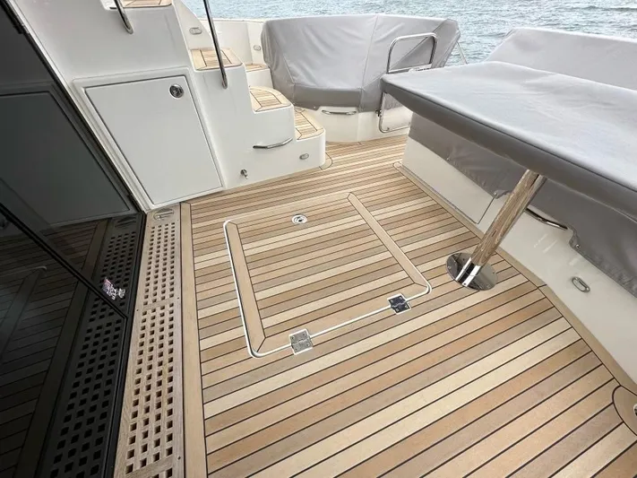  Yacht Photos Pics 2021 Carver C52 Command Bridge yacht deck with teak flooring and covered seating area.