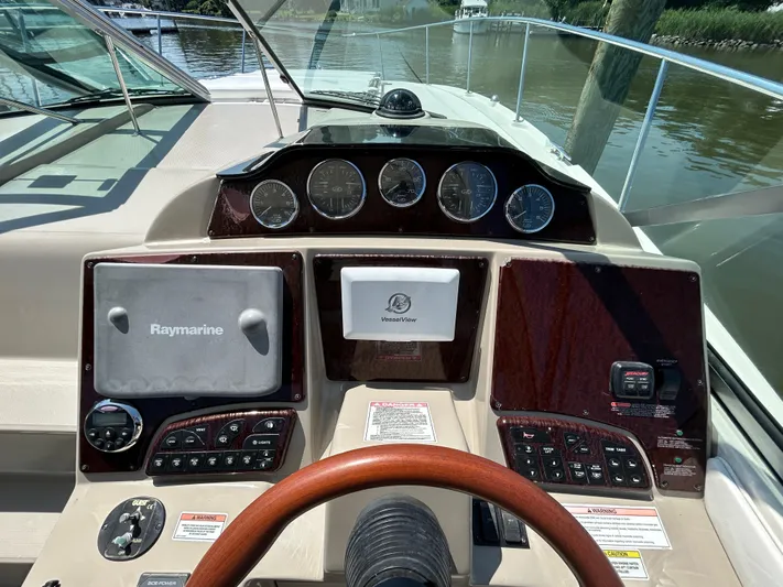  Yacht Photos Pics 2008 Sea Ray 330 Sundancer helm with Raymarine navigation system and wood-trimmed dashboard.