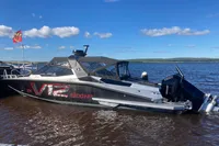 2022 Anytec A30 X-Tnd boat with twin V12 engines docked on a sunny day.