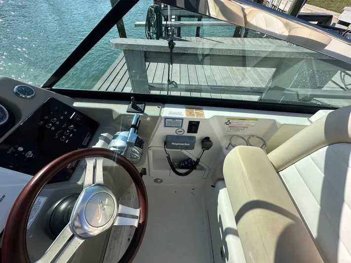  Yacht Photos Pics 2013 Sea Ray 370 Venture helm with steering wheel and control panel, dockside view.
