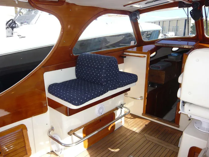 Courage Yacht Photos Pics Interior of 1998 Hinckley 36 Classic yacht with polished wood and blue cushioned seating.