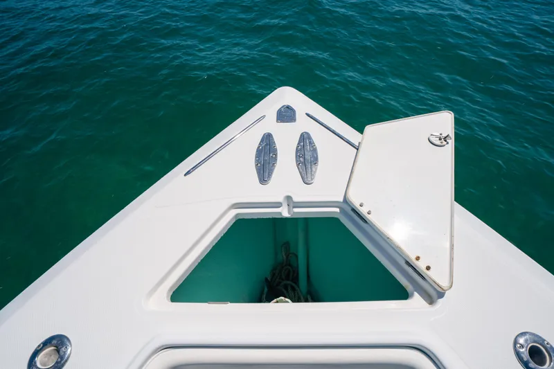  Yacht Photos Pics Bow of 2006 Venture 39 Open boat with open hatch, floating on clear blue water.