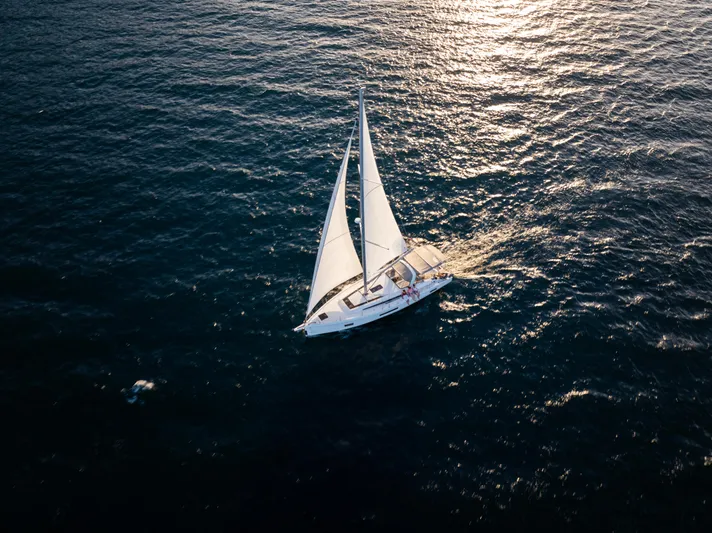 Sunday Girl Yacht Photos Pics 2024 Beneteau Oceanis 51.1 sailing on open sea at sunset.