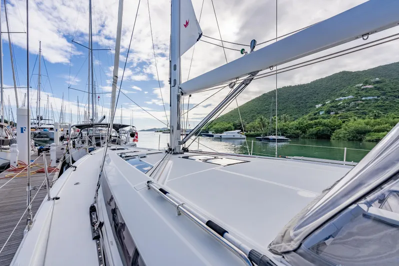 Sunday Girl Yacht Photos Pics 2024 Beneteau Oceanis 51.1 yacht docked, surrounded by lush green hills and calm waters.