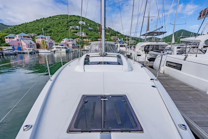 Sunday Girl Yacht Photos Pics 2024 Beneteau Oceanis 51.1 yacht docked in scenic marina with colorful buildings.