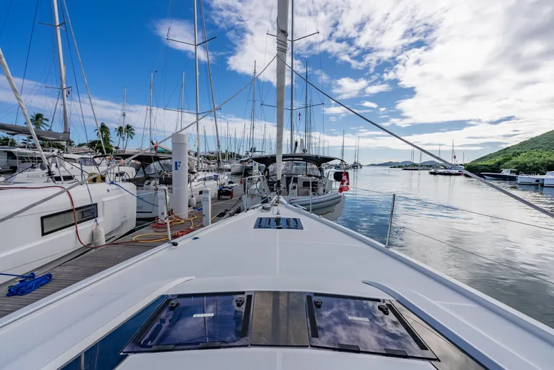 Sunday Girl Yacht Photos Pics 2024 Beneteau Oceanis 51.1 yacht docked in a scenic marina with clear skies.