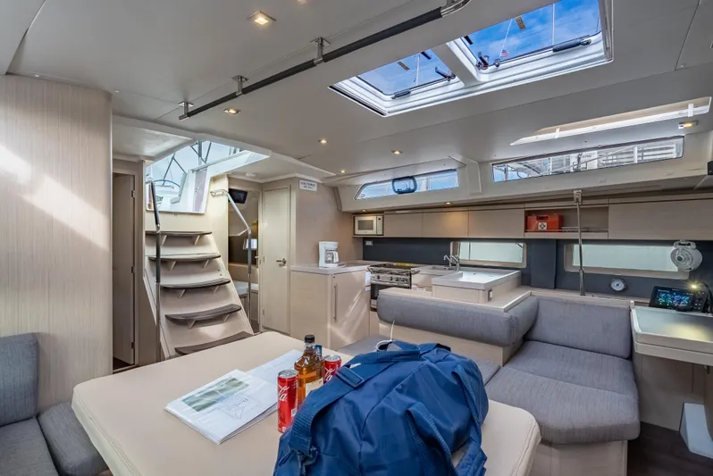 Sunday Girl Yacht Photos Pics Luxurious interior of 2024 Beneteau Oceanis 51.1 yacht with modern kitchen and seating area.