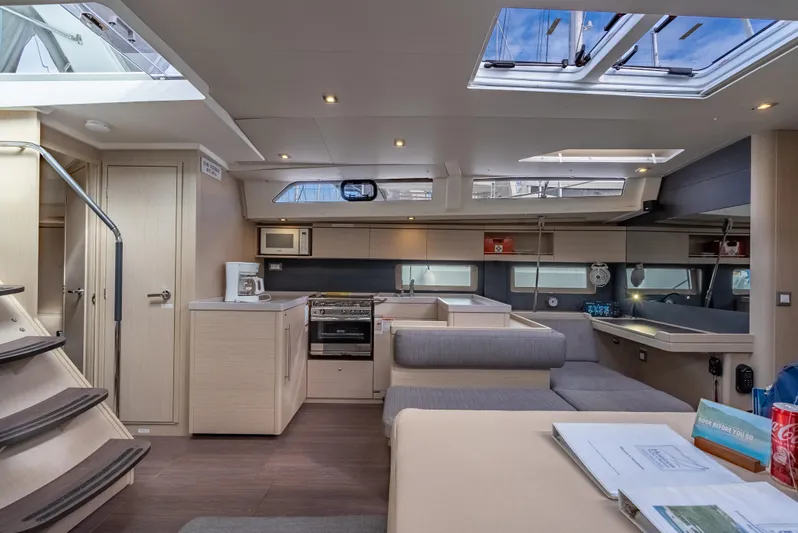 Sunday Girl Yacht Photos Pics Luxurious interior of 2024 Beneteau Oceanis 51.1 yacht with modern kitchen and seating area.