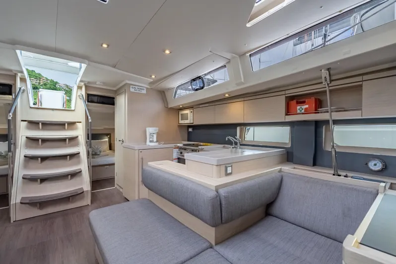 Sunday Girl Yacht Photos Pics Luxurious interior of 2024 Beneteau Oceanis 51.1 yacht with modern kitchen and seating area.