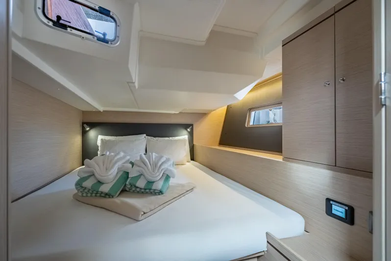 Sunday Girl Yacht Photos Pics Luxurious cabin interior of 2024 Beneteau Oceanis 51.1 yacht with elegant bedding and storage.