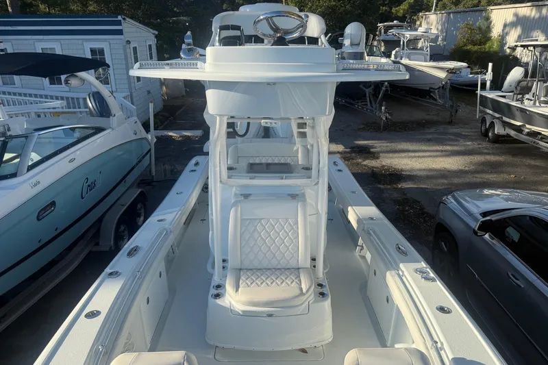  Yacht Photos Pics 2022 Yellowfin 26 Hybrid boat with sleek design and spacious seating, docked outdoors.