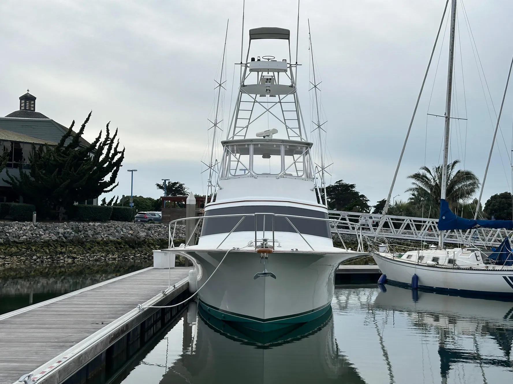 1988 Buddy Davis Convertible yacht docked at marina, front view with calm water reflection.