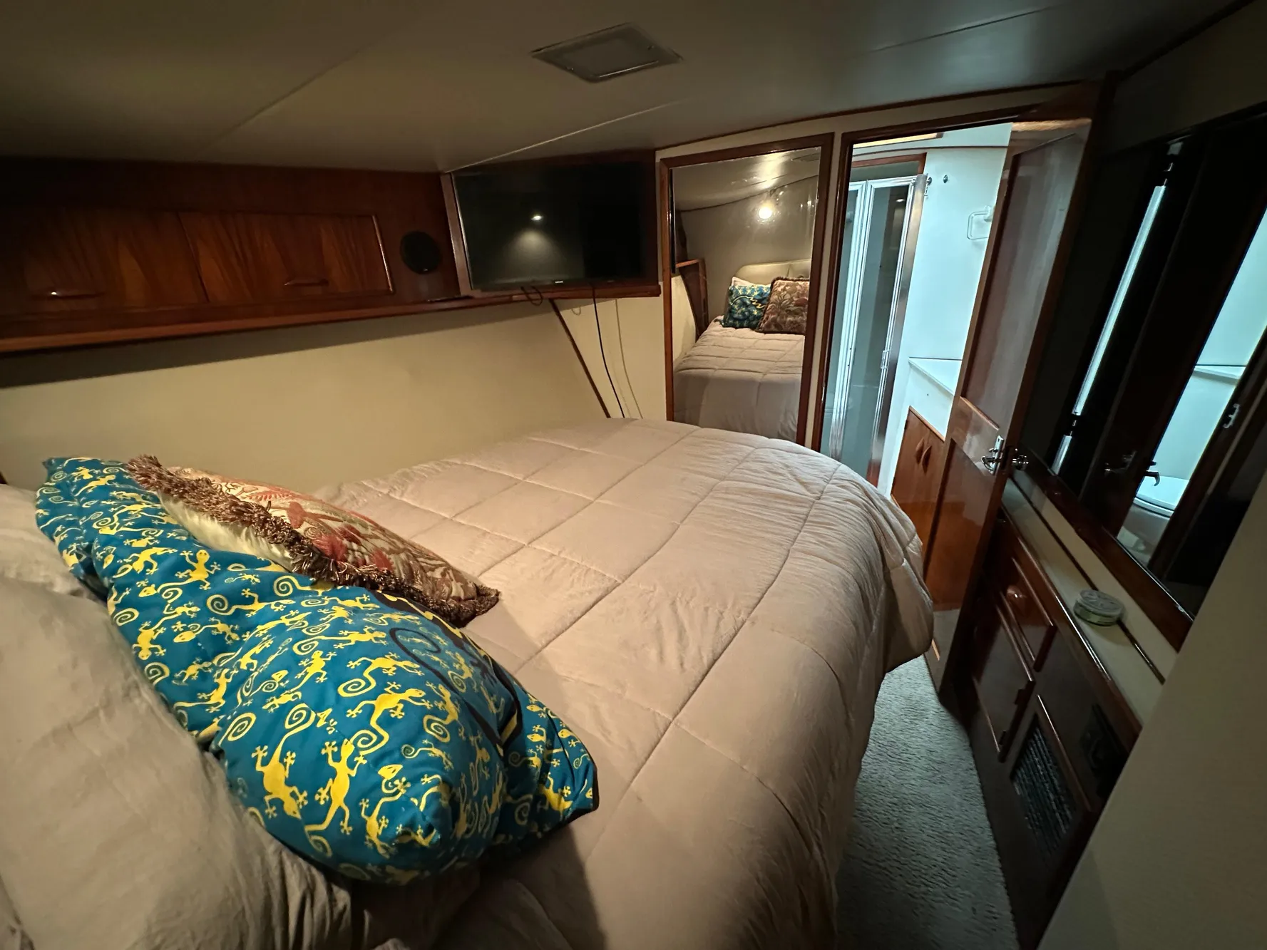 Cozy bedroom in 1988 Buddy Davis Convertible yacht with plush bedding and wood accents.