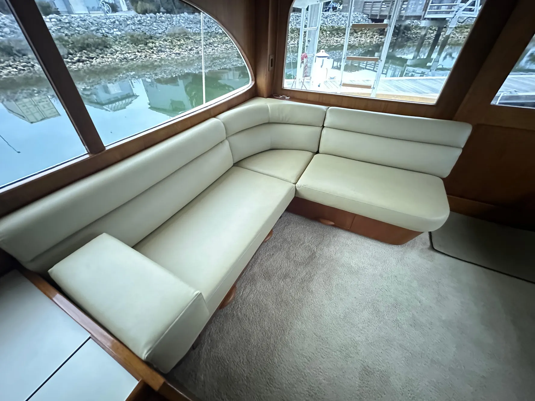 1988 Buddy Davis Convertible yacht interior with beige leather seating and large windows.