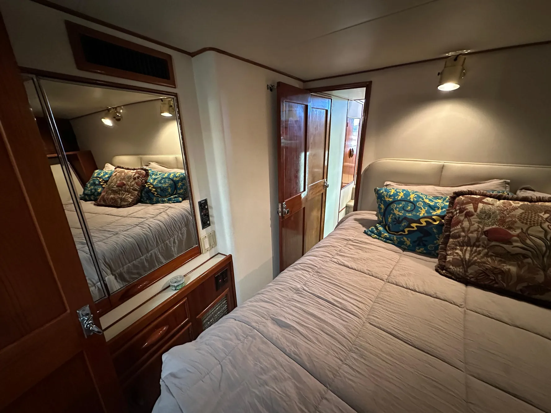 Cozy bedroom in 1988 Buddy Davis Convertible yacht with plush bedding and mirrored closet.