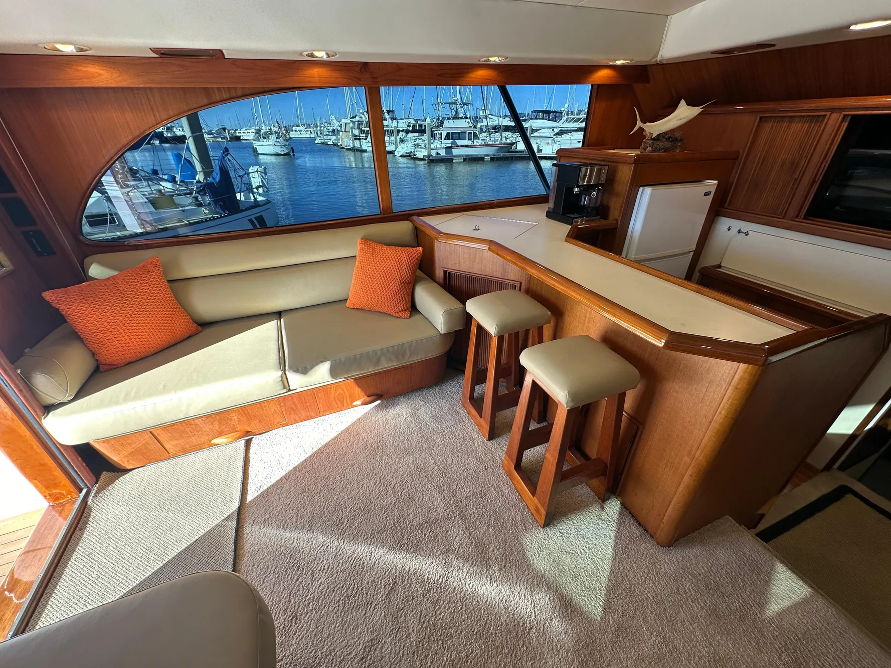 Luxurious 1988 Buddy Davis Convertible yacht interior with seating, bar stools, and marina view.