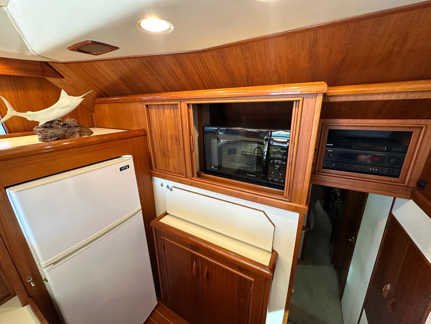 1988 Buddy Davis Convertible yacht interior with wood cabinetry, microwave, and refrigerator.
