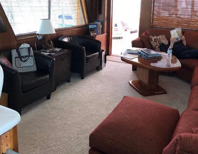 The Bottom Line Yacht Photos Pics Interior of 1987 Hatteras Flybridge yacht with cozy seating and wooden table.