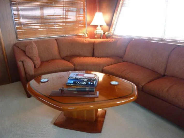 The Bottom Line Yacht Photos Pics Luxurious 1987 Hatteras Flybridge interior with cozy seating and elegant wooden table.
