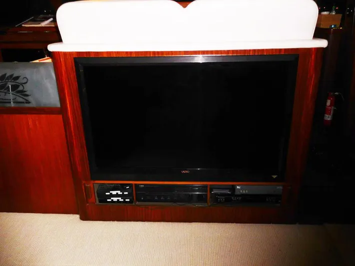 The Bottom Line Yacht Photos Pics 1987 Hatteras Flybridge interior with built-in Vizio TV and entertainment system.