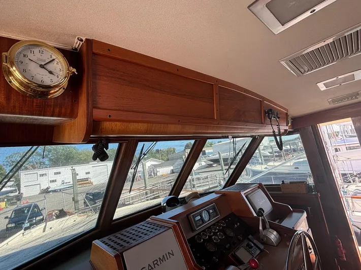 The Bottom Line Yacht Photos Pics Interior view of 1987 Hatteras Flybridge helm with vintage clock and navigation equipment.