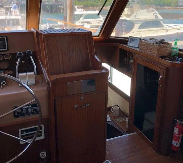 The Bottom Line Yacht Photos Pics 1987 Hatteras Flybridge interior with wooden helm, steering wheel, and control panel.