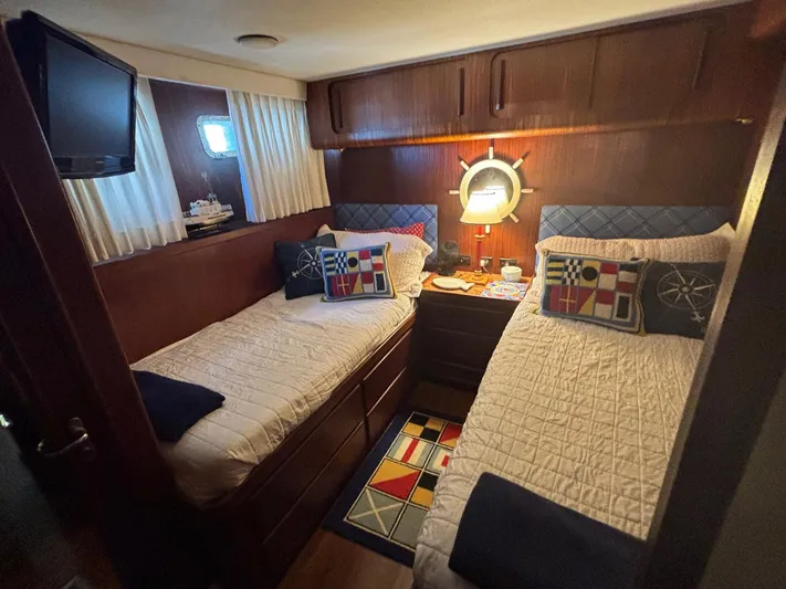 The Bottom Line Yacht Photos Pics Cozy cabin interior of 1987 Hatteras Flybridge with twin beds and nautical decor.
