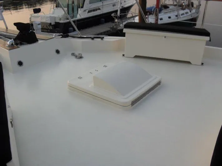 The Bottom Line Yacht Photos Pics 1987 Hatteras Flybridge deck with hatch and seating, docked at marina.