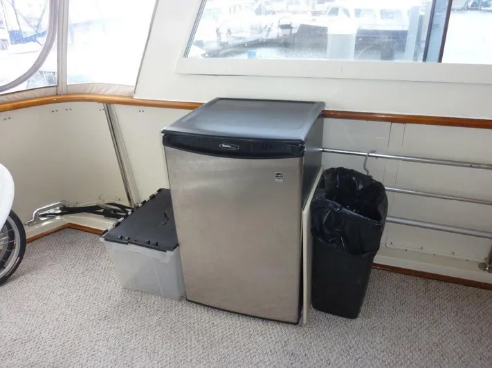 The Bottom Line Yacht Photos Pics Interior of 1987 Hatteras Flybridge with mini fridge and trash bin.