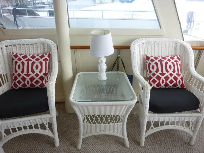 The Bottom Line Yacht Photos Pics White wicker chairs and table with red patterned cushions on a 1987 Hatteras Flybridge.