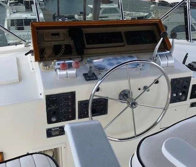 The Bottom Line Yacht Photos Pics 1987 Hatteras Flybridge helm with steering wheel and control panel.