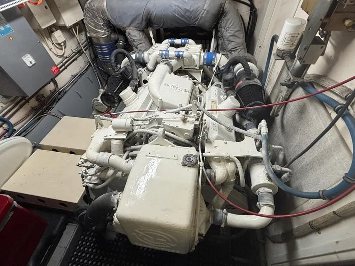 The Bottom Line Yacht Photos Pics Engine room of a 1987 Hatteras Flybridge yacht, showcasing complex machinery and piping.