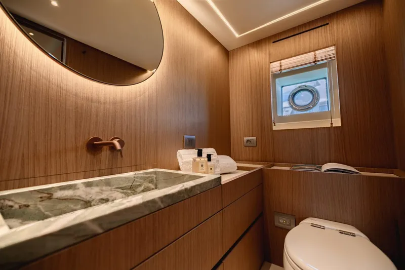  Yacht Photos Pics Luxurious bathroom in 2025 Azimut Seadeck 7 yacht with modern fixtures and porthole window.