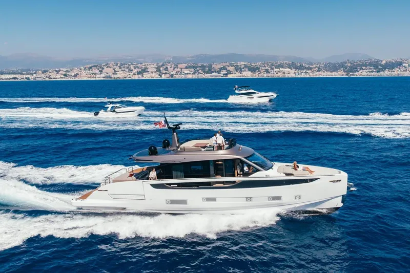  Yacht Photos Pics 2025 Azimut Seadeck 7 yacht cruising on blue ocean with scenic coastal backdrop.