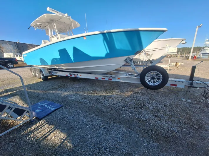 Salt Break Yacht Photos Pics 2020 Contender 32T boat on trailer, vibrant blue hull, parked on gravel lot.